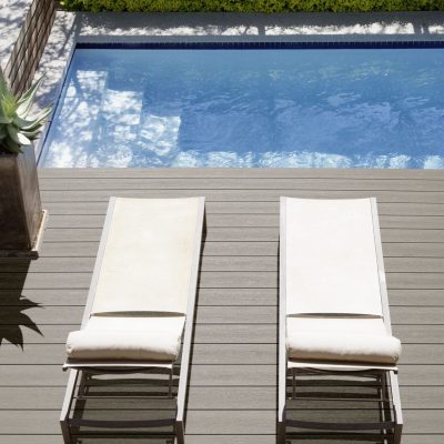 Modern lounge chairs next to swimming pool